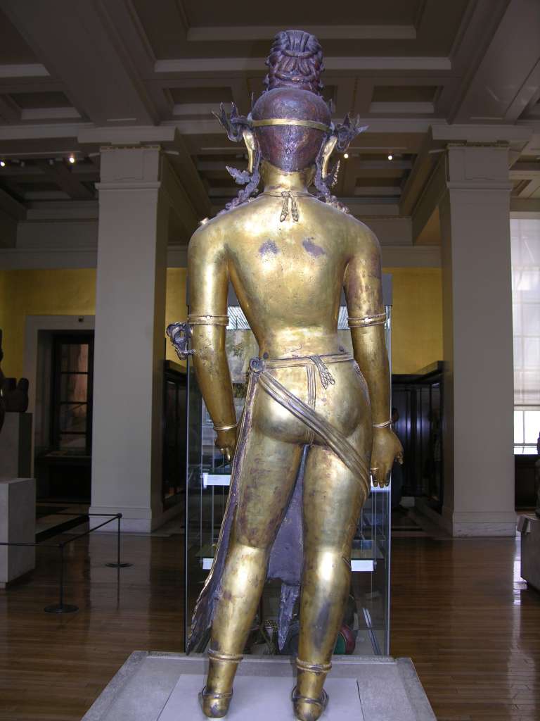 British Museum Top 20 Buddhism 09-2 Standing Avalokiteshvara Back Standing Avalokiteshvara � Nepal, 16C AD, 138cm high. Here is a view from behind Avalokiteshvara. This very large image was made in gilded bronze in several pieces. Rivets above the waist and above the elbows hold the figure together.